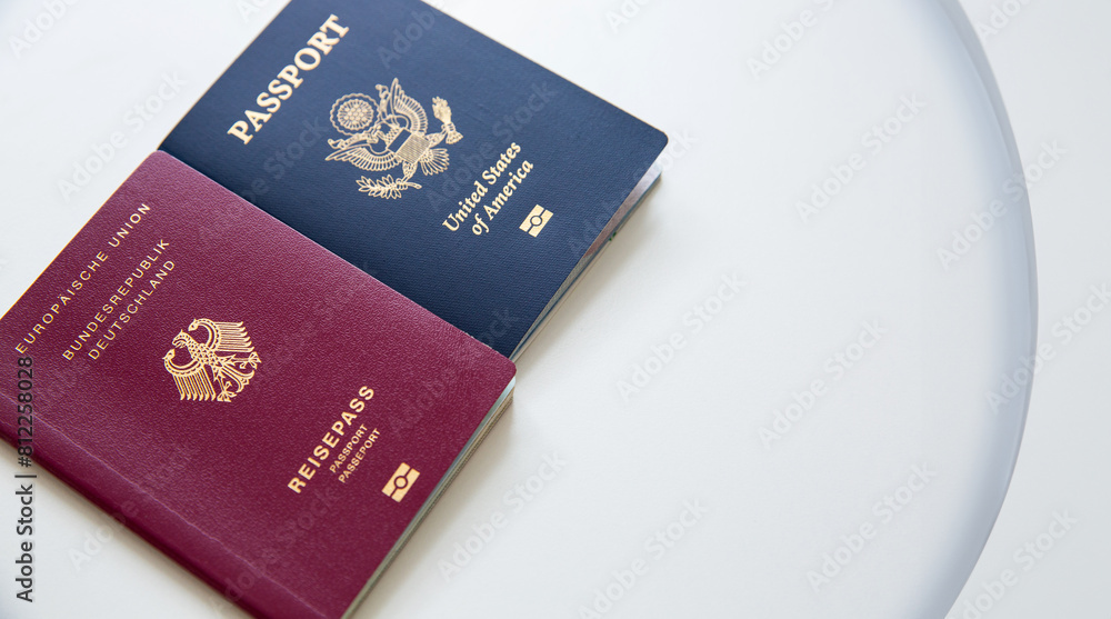 Close up of an American and German passports on white table Close up of an American and German passports on white table