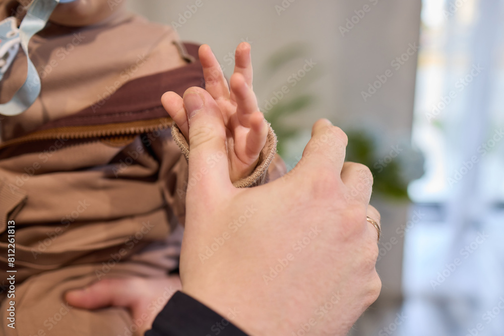 A close up of a persons thumb touching a baby tiny finger A close up of a persons thumb touching a baby tiny finger