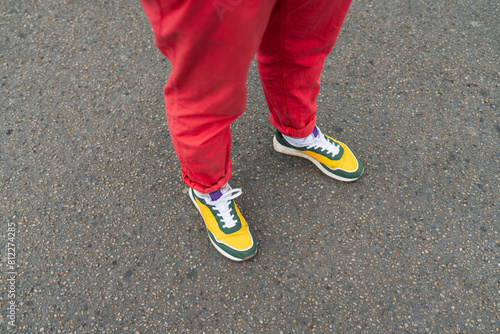 Legs of a man in fashionable pants and sneakers, hipster style
