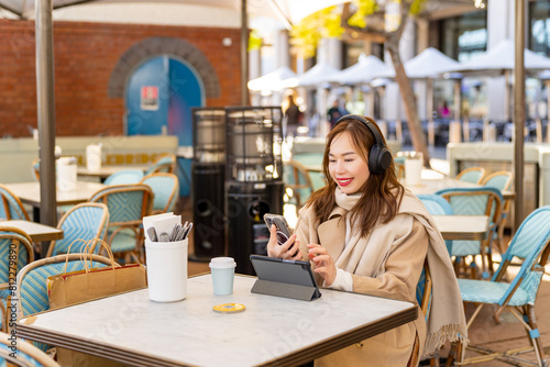 Photography Asian businesswoman remote working on digital tablet for online corporate business economic financial at outdoor cafe in the city