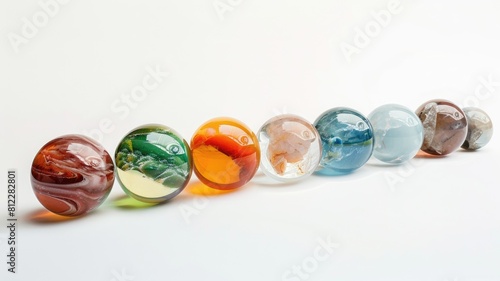 Series of colorful glass spheres aligned diagonally on white background