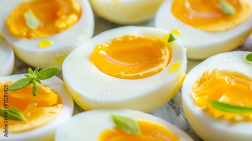 Soft-boiled eggs cut in half garnished with fresh herbs on a wooden surface.