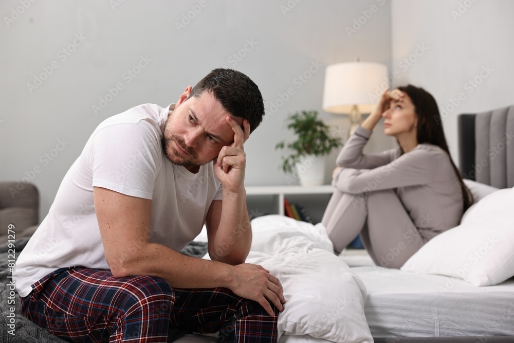 Offended couple ignoring each other after quarrel in bedroom, selective focus. Relationship problems Offended couple ignoring each other after quarrel in bedroom, selective focus. Relationship problems