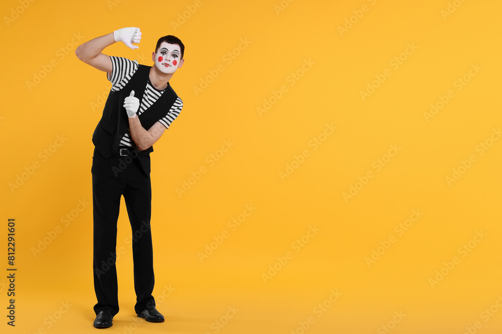 Funny mime artist posing on orange background. Space for text Funny mime artist posing on orange background. Space for text