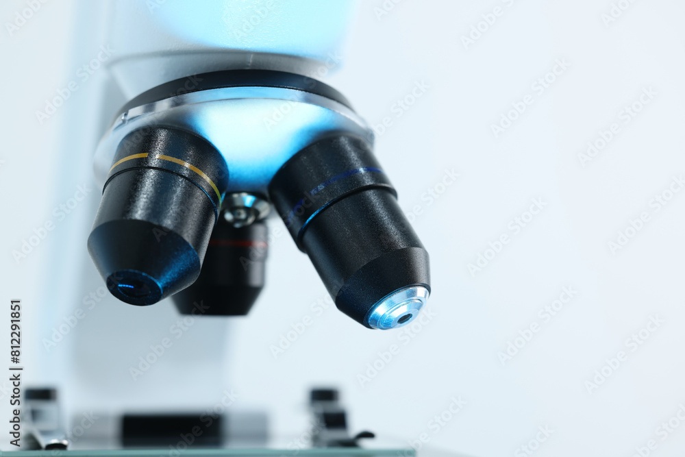Modern microscope on light background, closeup view Modern microscope on light background, closeup view