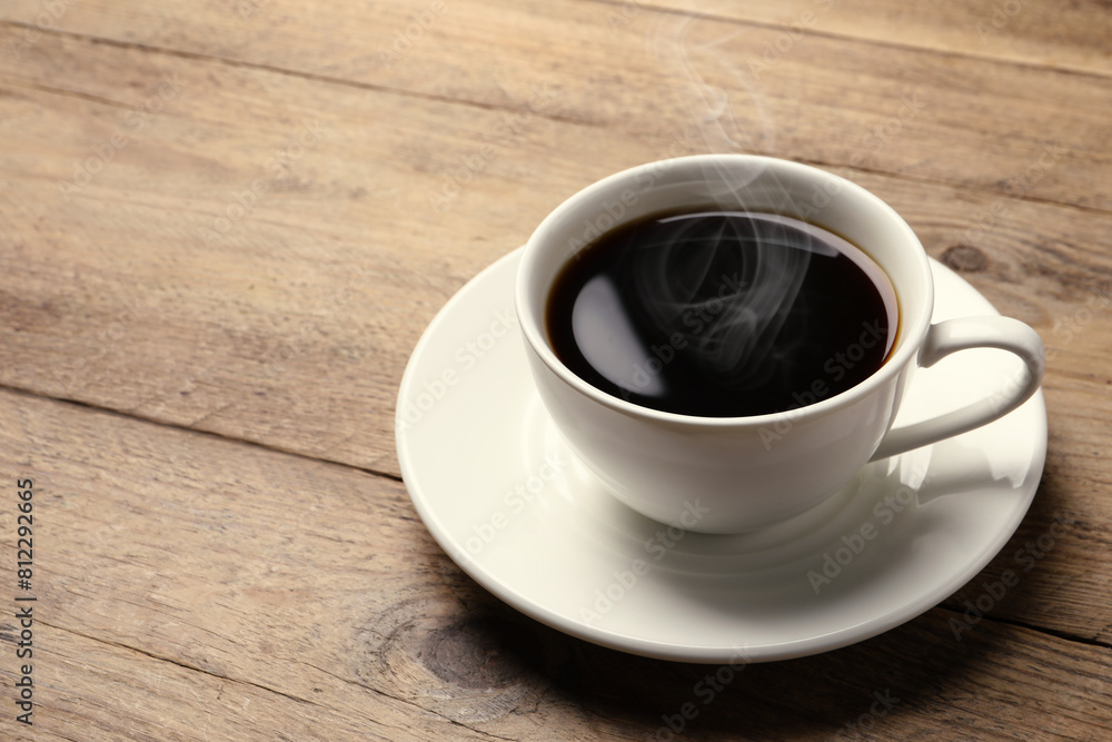 Steaming coffee in cup on wooden table. Space for text Steaming coffee in cup on wooden table. Space for text