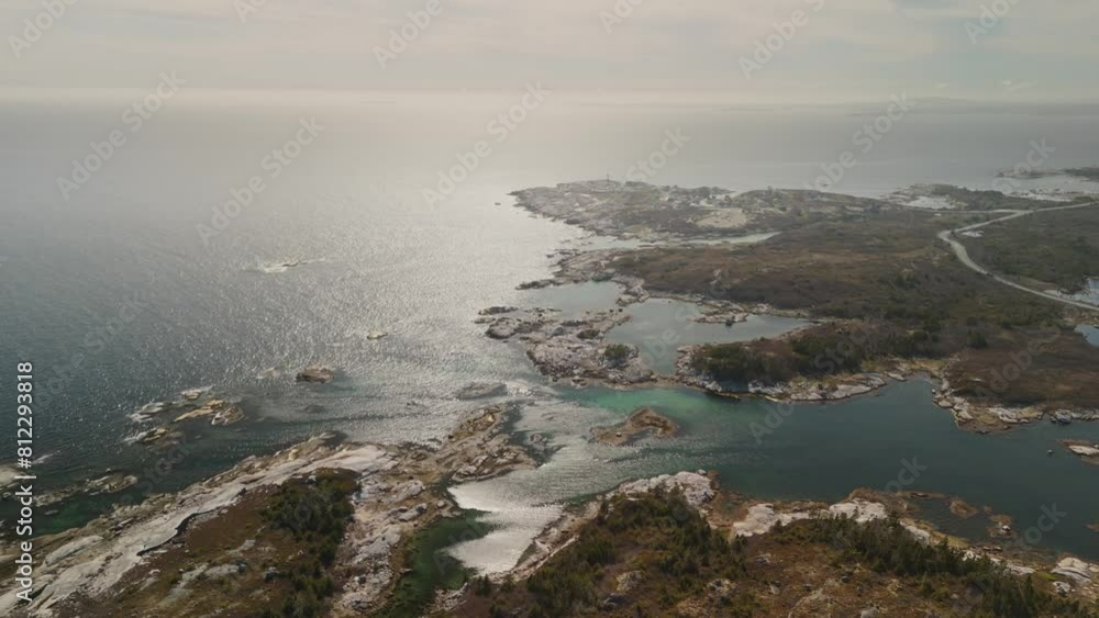 Drone soars over rugged coastline Nova Scotia, Peggy's Cove comes into view like a painting come to life.Rocky shore stretches out in all directions, battered by relentless waves Atlantic Ocean Drone soars over rugged coastline Nova Scotia, Peggy's Cove comes into view like a painting come to life.Rocky shore stretches out in all directions, battered by relentless waves Atlantic Ocean