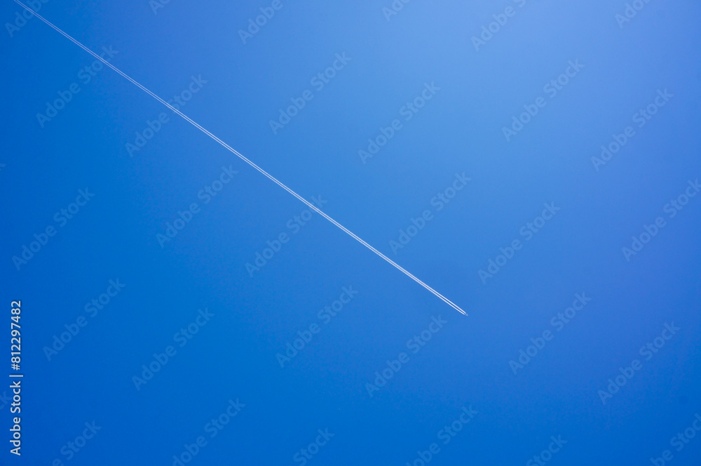 Fototapeta premium 青空に美しく描かれた一直線に伸びる飛行機雲