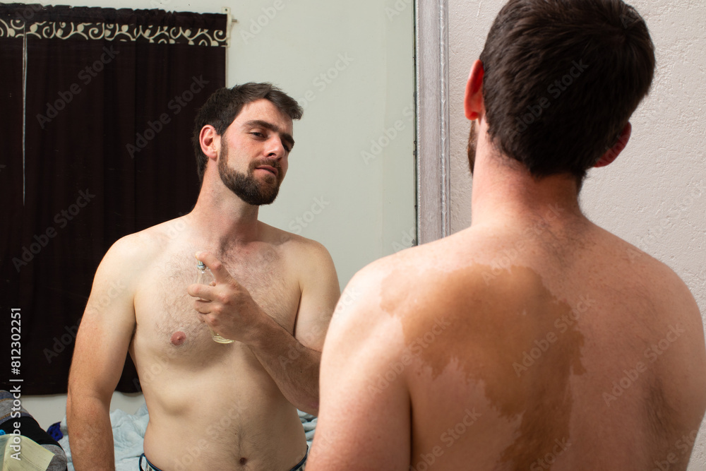 good looking man applying perfume fragrance on body, young man with diverse skin stain or mole, i feel so happy in my skin good looking man applying perfume fragrance on body, young man with diverse skin stain or mole, i feel so happy in my skin