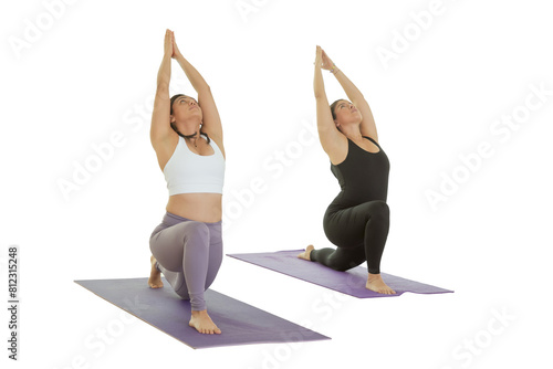 Two young Mexican women practice yoga indoors in a studio