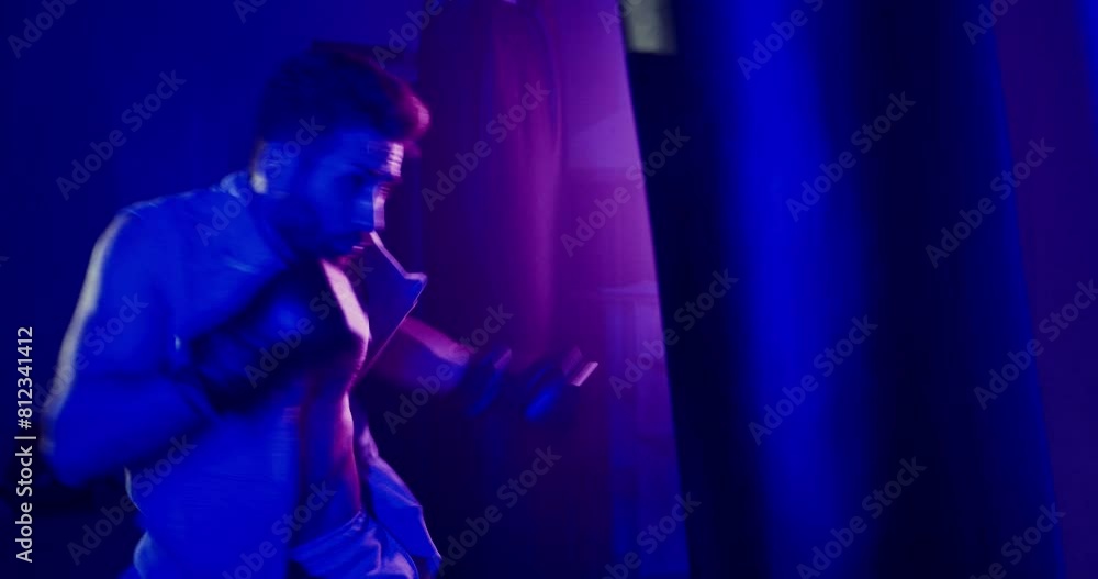 Man Boxing Punching Bag in Neon-lit Gym Man Boxing Punching Bag in Neon-lit Gym