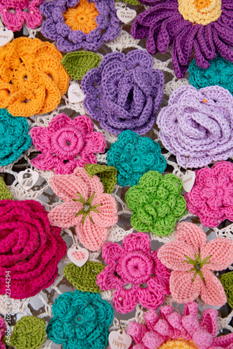 A colorful crochet flower blanket with many different colored flowers