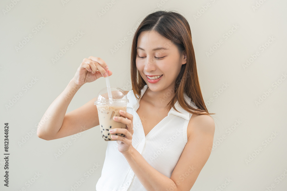 Beverage and food concept, Happy asian young woman hand holding plastic cup, glass of drink bubble, pearl milk tea with straw, cute girl drinking ice cold tea with tapioca boba ball popular in Taiwan. Beverage and food concept, Happy asian young woman hand holding plastic cup, glass of drink bubble, pearl milk tea with straw, cute girl drinking ice cold tea with tapioca boba ball popular in Taiwan.