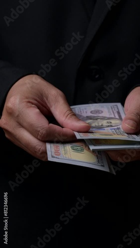 A man is holding a stack of $100 dollar bills. Concept of wealth and prosperity