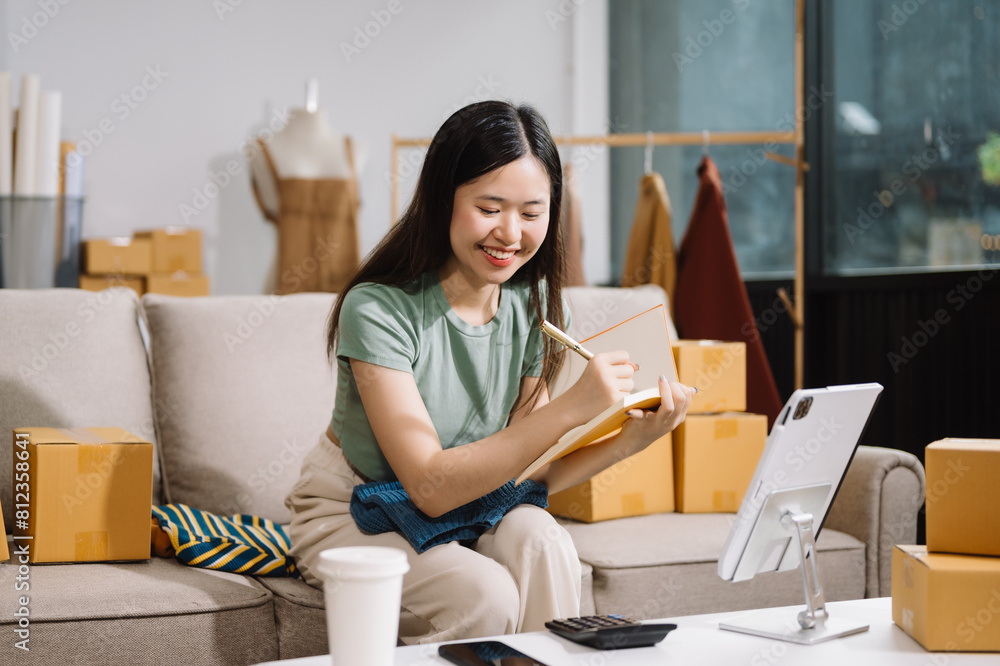 Startup small business SME, Entrepreneur owner woman using smartphone or tablet taking receive and checking online purchase shopping order Startup small business SME, Entrepreneur owner woman using smartphone or tablet taking receive and checking online purchase shopping order