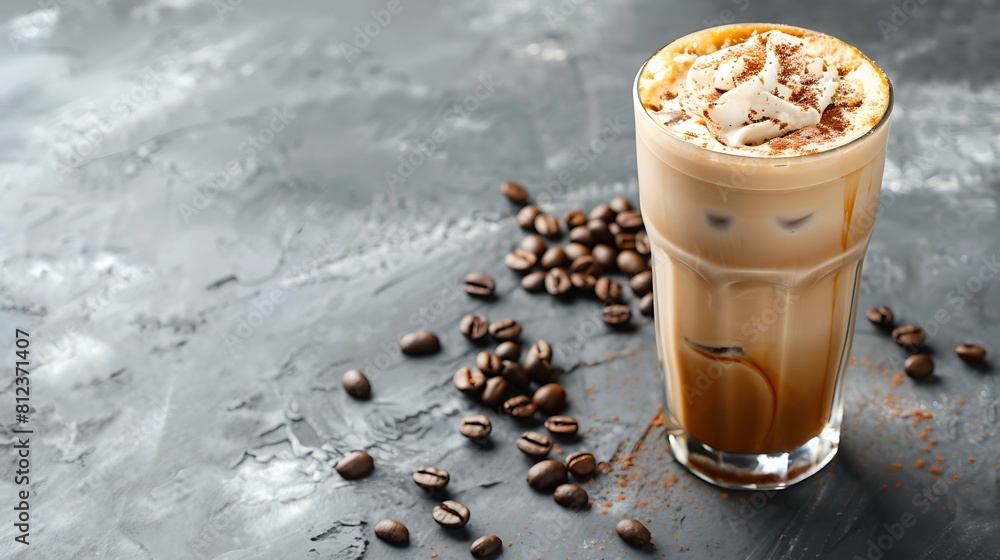 Ice coffee in a tall glass with cream poured over and coffee beans on a grey stone background Ice coffee in a tall glass with cream poured over and coffee beans on a grey stone background