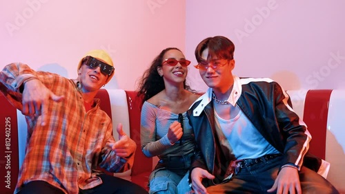 Happy dancing team wearing fancy glasses while moving to city pop or hip hop music. Professional performer group sitting at modern restaurant while perform funny freestyle dance together. Regalement. photo