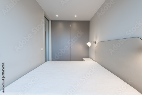 Minimalism Bedroom Interior. Wardrobe in Background. Coffee Table and Light