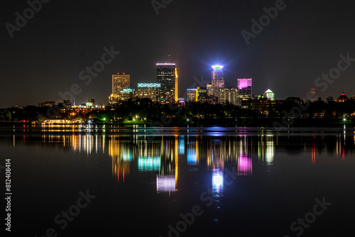 Minneapolis skyline at night reflecting off the waters of Lake Bde Maka Ska in Minnesota on a clear summer night