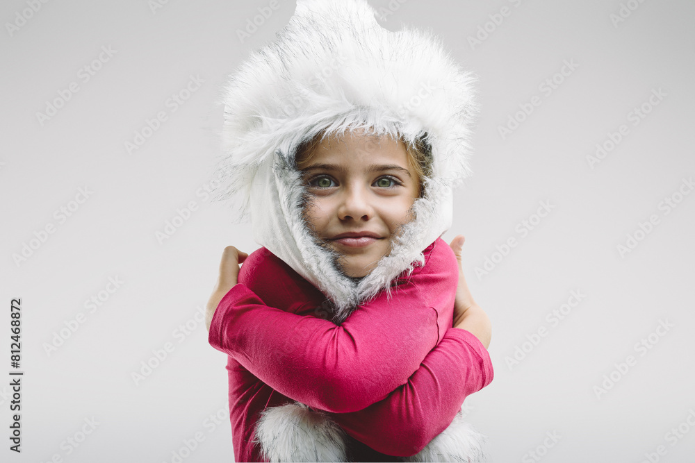 Girl in white hat hugs herself, smiles warmly Girl in white hat hugs herself, smiles warmly