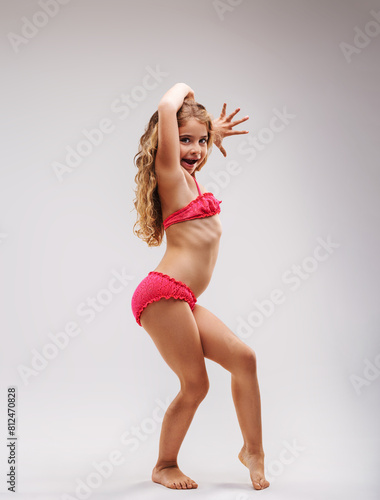 Little girl in pink bango costume poses like a rock star