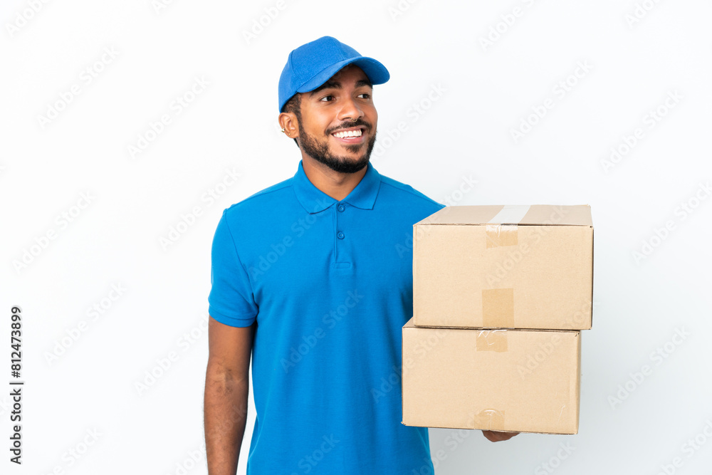 Delivery Ecuadorian man isolated on white background looking to the side and smiling Delivery Ecuadorian man isolated on white background looking to the side and smiling