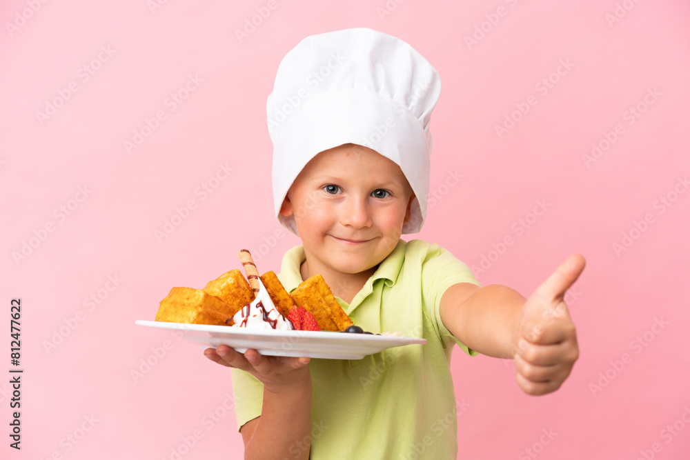 Little Russian boy holding waffles over isolated background Little Russian boy holding waffles over isolated background