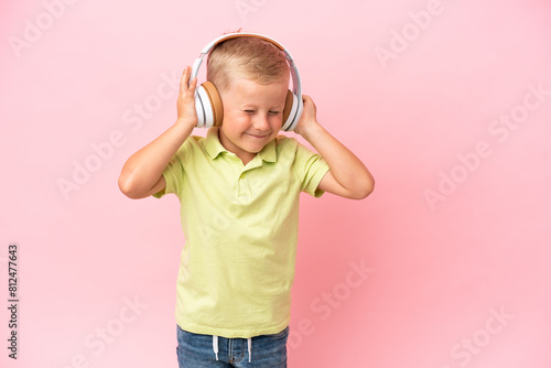Little Russian boy listening to music with headphones over isolated background