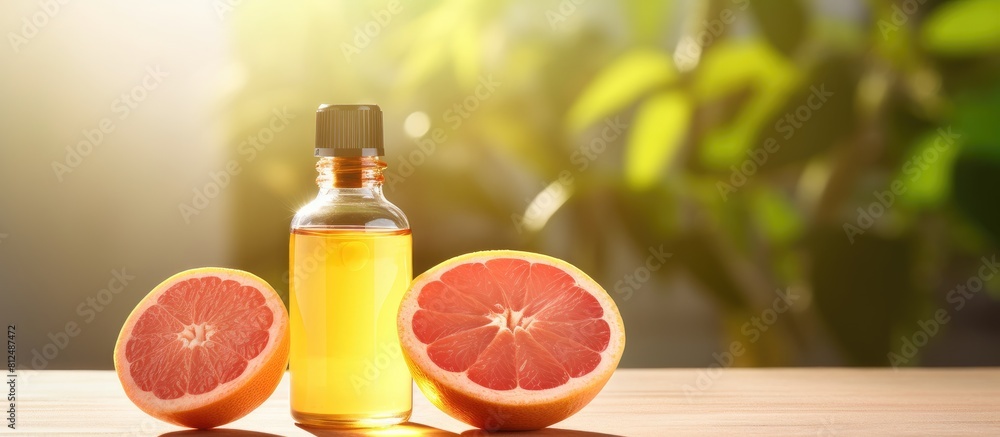 Close up photo of grapefruit essential oil in a bottle alongside a fresh fruit placed on a well lit table There is empty space available for adding text. Creative banner. Copyspace image Close up photo of grapefruit essential oil in a bottle alongside a fresh fruit placed on a well lit table There is empty space available for adding text. Creative banner. Copyspace image