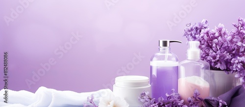 Lilac background with a collection of bath supplies and cosmetic products creating a copy space image