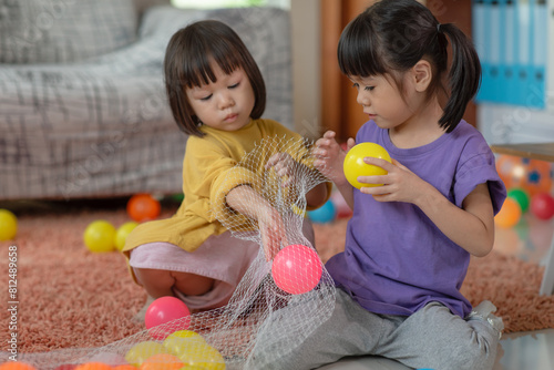 Asian family loving children, kid and her sister collecting plastic toy balls