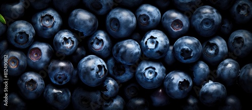 A top down view of ripe organic blueberries arranged on a black background capturing the essence of summer berries The image features a flat layout with ample copy space