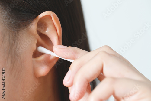 close up female cleaning ear using cotton stick for Healthcare.