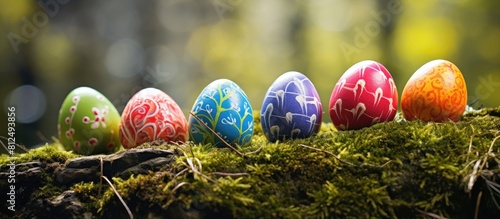 Colorful Easter eggs hand painted in accordance with the Sorbian tradition are displayed outdoors on a bed of moss with ample copy space photo
