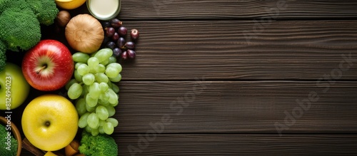Top view of a healthy eating concept with a variety of nutritious foods like green apples bananas eggs and vegetables arranged on a wooden background The image also includes a measuring tape dumbbell photo