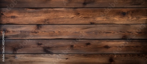 A horizontal wooden background with a dark texture provides an empty surface offering ample space for a design or copy space image
