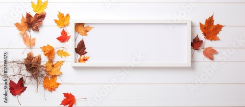 A copy space image featuring a text overlay framed by autumn leaves on a white wooden background