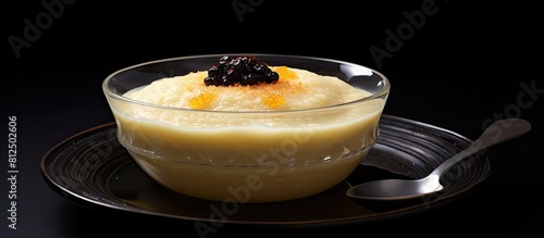 A bowl of Noah s pudding a traditional Turkish dessert is placed on a black slate background providing space for copy or additional images photo