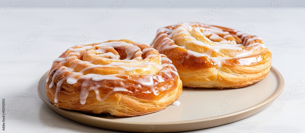 A breakfast or tea time treat of puff pastry buns adorned with a white glaze displayed on a light table Perfect for indulging in tasty delights Copy space image A breakfast or tea time treat of puff pastry buns adorned with a white glaze displayed on a light table Perfect for indulging in tasty delights Copy space image