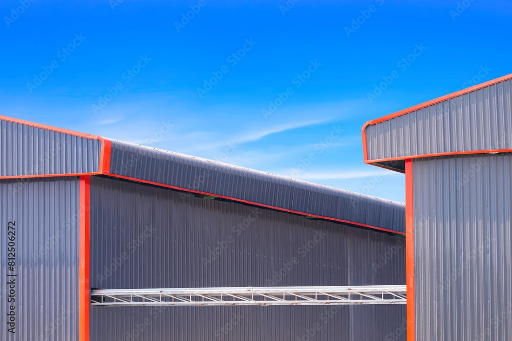 Overhead electrical cable ladder and cable tray for installing power and control cable lines is connecting with two industrial buildings against blue sky background Overhead electrical cable ladder and cable tray for installing power and control cable lines is connecting with two industrial buildings against blue sky background
