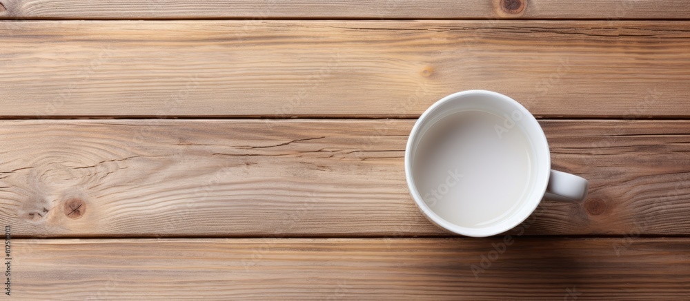 Top view of a white cup placed on a wooden surface showcasing an empty space in the image. Creative banner. Copyspace image Top view of a white cup placed on a wooden surface showcasing an empty space in the image. Creative banner. Copyspace image