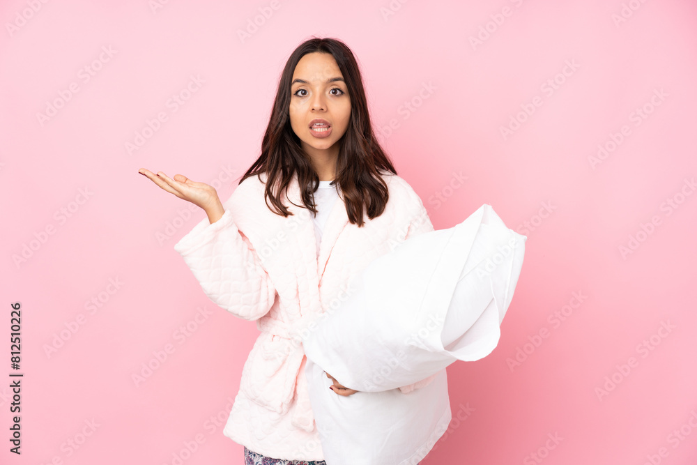 Young woman in pajamas isolated on pink background making doubts gesture Young woman in pajamas isolated on pink background making doubts gesture