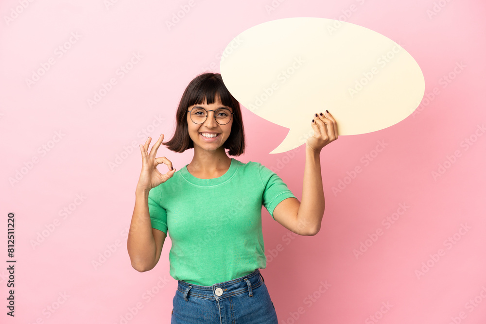 Youing woman holding an empty speech bubble and doing OK sign Youing woman holding an empty speech bubble and doing OK sign