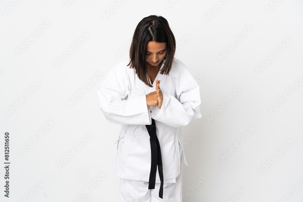 Young latin woman isolated on white background doing karate and saluting Young latin woman isolated on white background doing karate and saluting