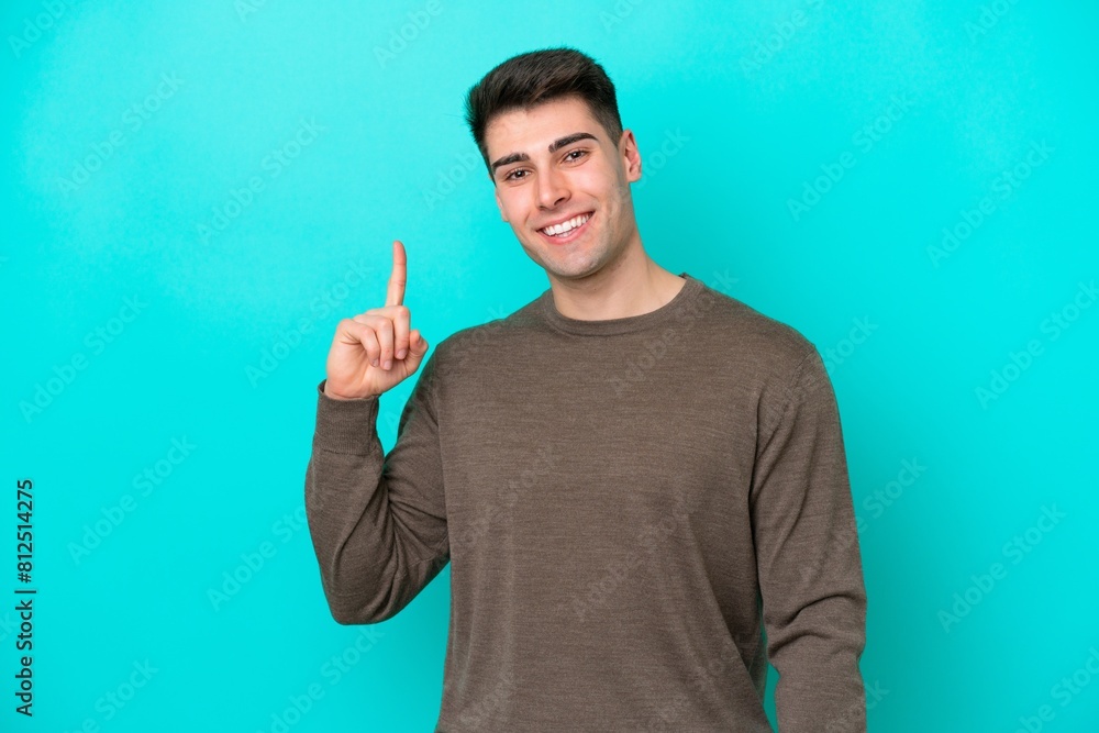 Young caucasian man isolated on blue background showing and lifting a finger in sign of the best Young caucasian man isolated on blue background showing and lifting a finger in sign of the best