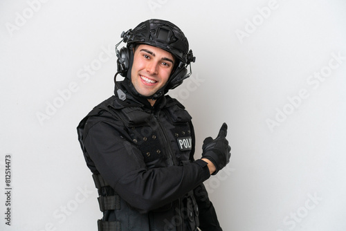 SWAT caucasian man isolated on white background pointing back © luismolinero