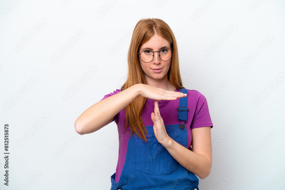 Young redhead woman isolated on white background making time out gesture Young redhead woman isolated on white background making time out gesture