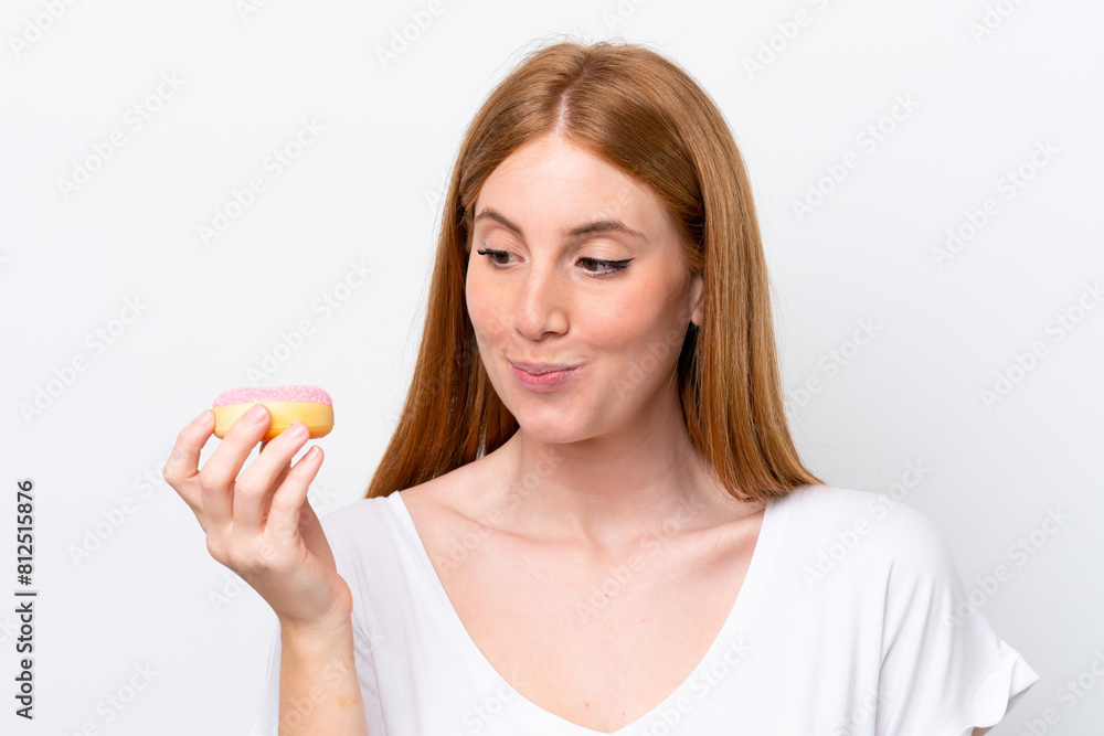 Young redhead woman isolated on white background holding a donut Young redhead woman isolated on white background holding a donut