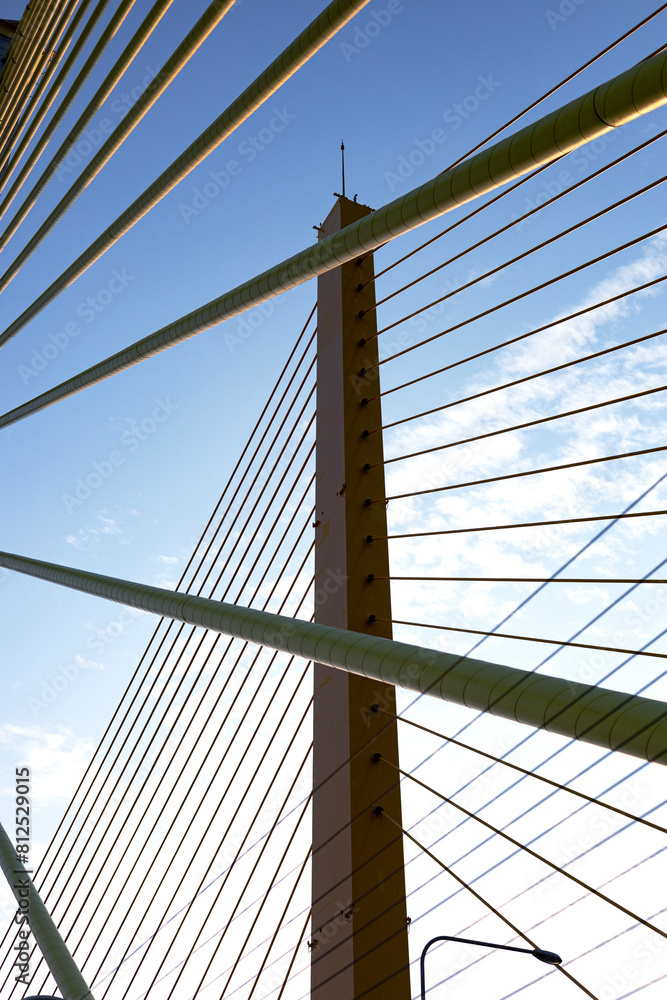 Fototapeta premium Yellow Cables On A Suspension Bridge Against Blue Sky In Bangkok