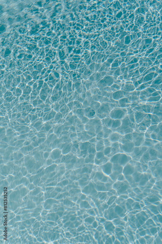 Obraz premium Beautiful view of swimming pool surface with clear blue water with sunlight reflections on wave. Summer vacation concept background